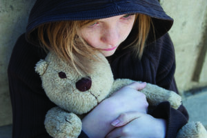 Little girl clutches teddy